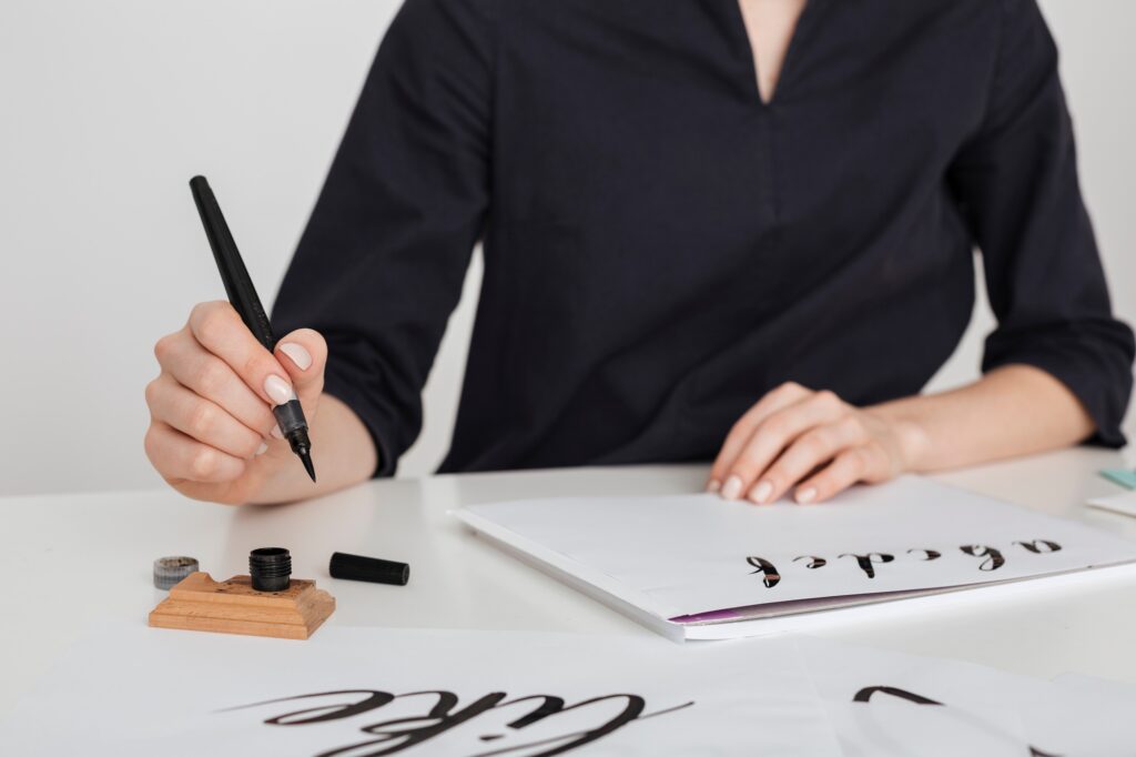 Beautiful photo of young woman hands writing on paper on desk isolated